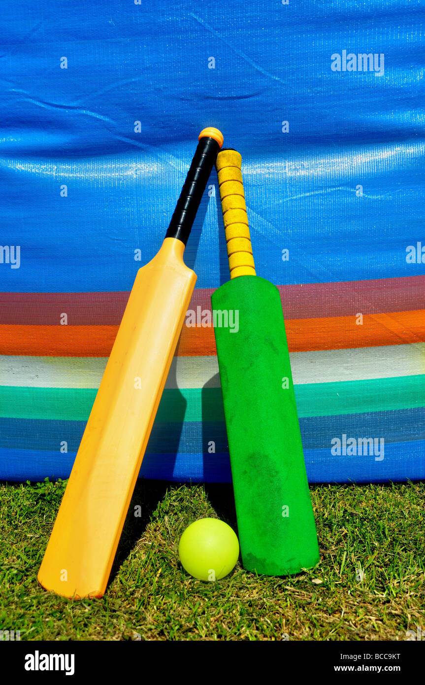 Zwei Spielzeug Kricketschläger anlehnen ein Wind-Stopper. Stockfoto