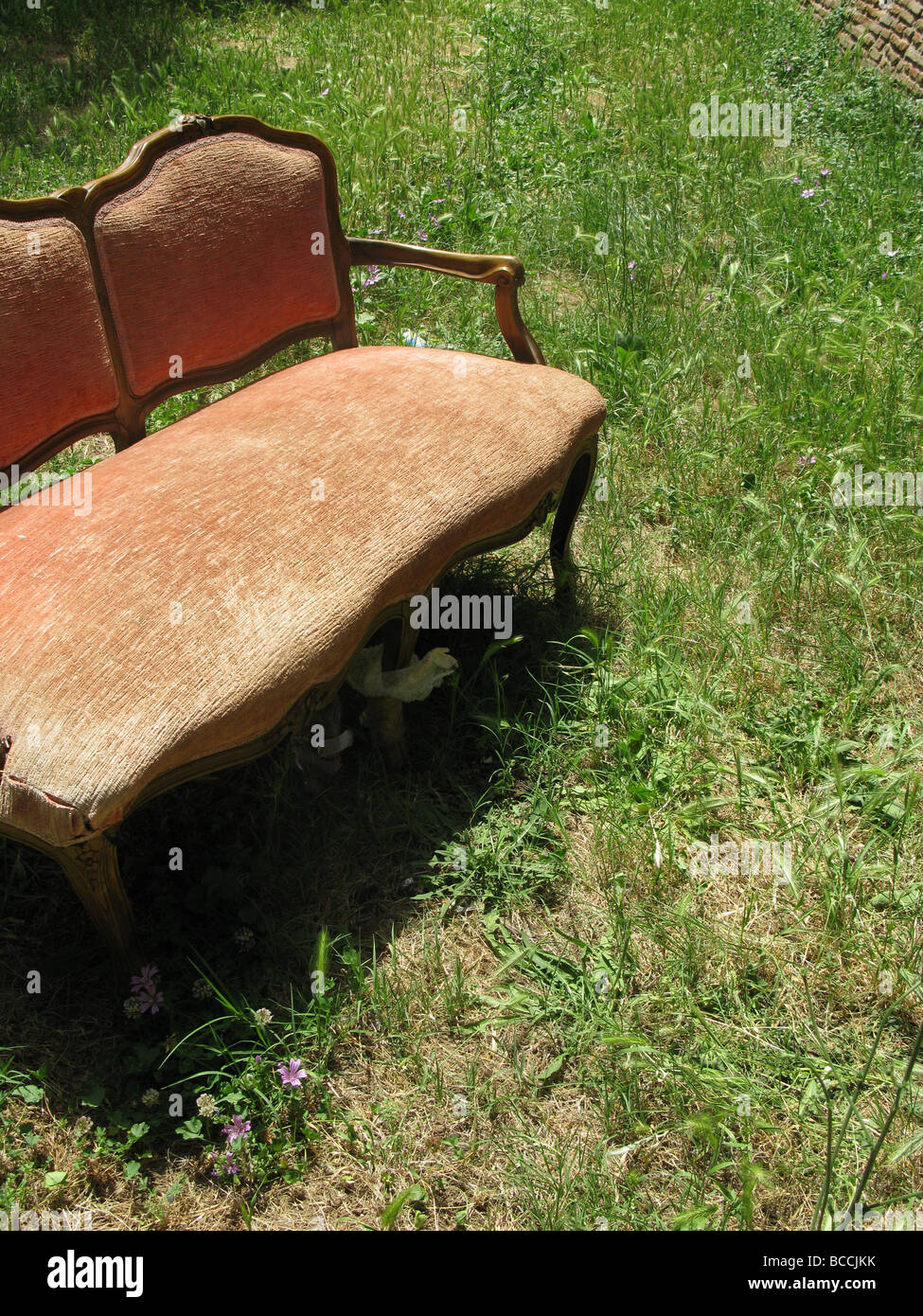 eine alte beschädigte Sofa in Feld auf Land entsorgt Stockfoto