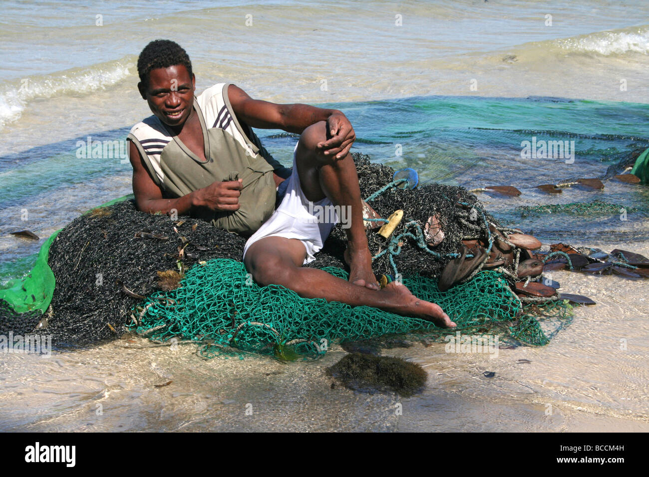 Madagassische Fischer ruht auf seine Netze auf Ifaty Strand, Madagaskar Stockfoto