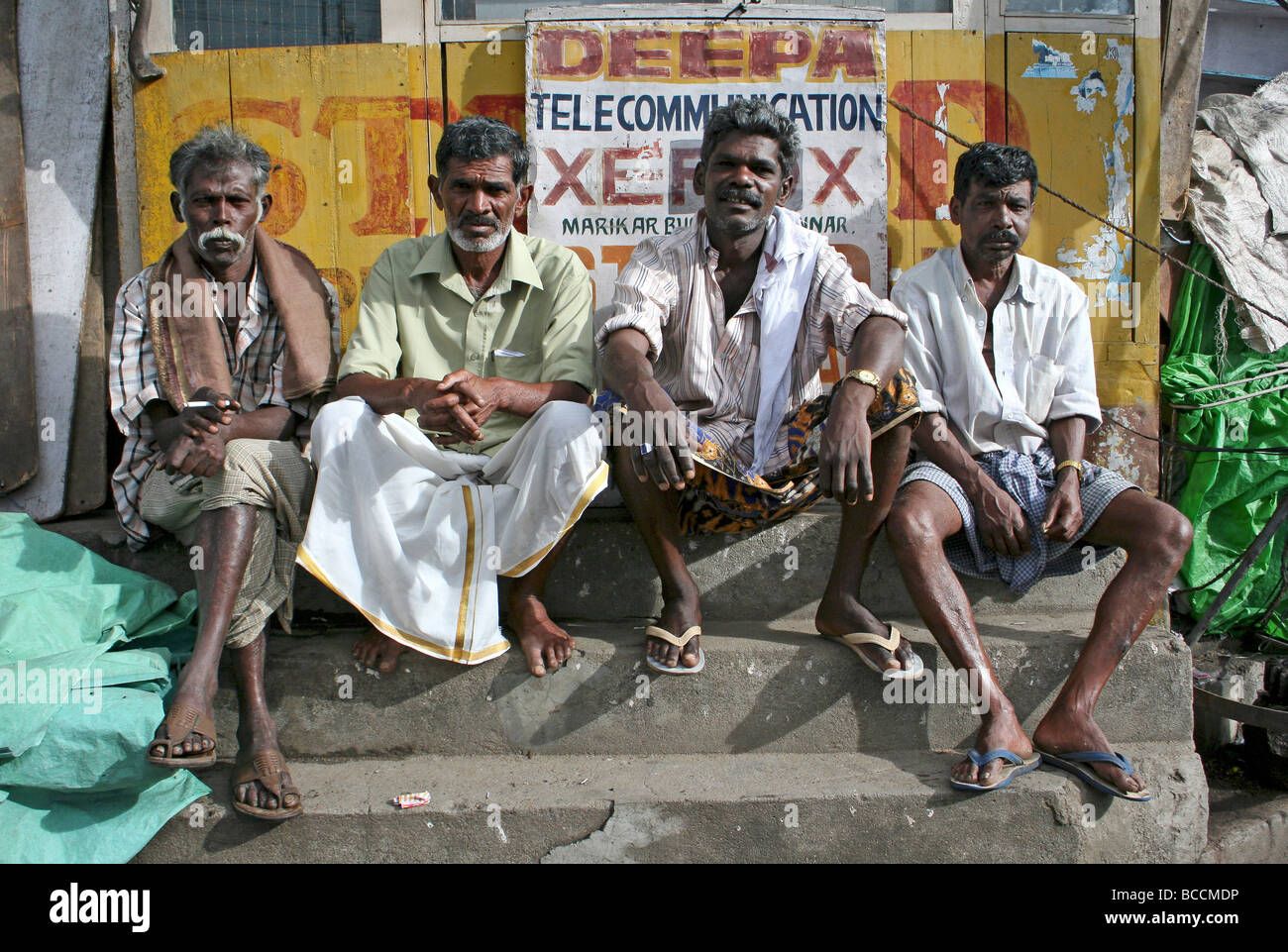 Vier indische Männer saßen In einer Stadt Markt, Munnar, Kerala, Indien Stockfoto
