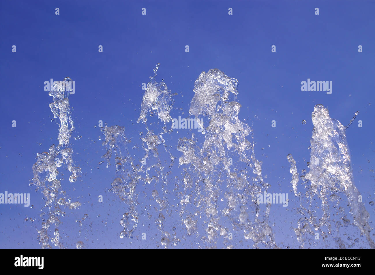 Wasser sprühen in die Luft vor blauem Himmel Stockfoto