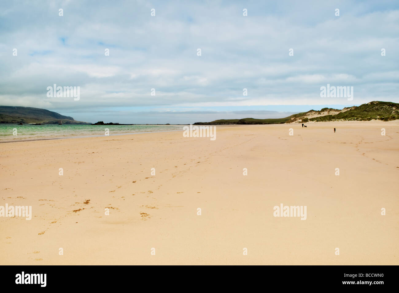 Sandstrand und die Bucht von Balnakeil Bucht, Durness, Sutherland in Schottland mit Mann zu Fuß Hunde in der Ferne Stockfoto