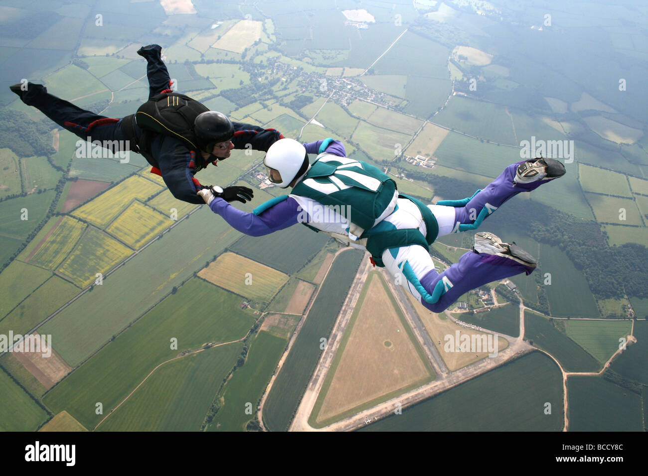 Zwei Fallschirmspringer im freien Fall Hand in Hand Stockfoto