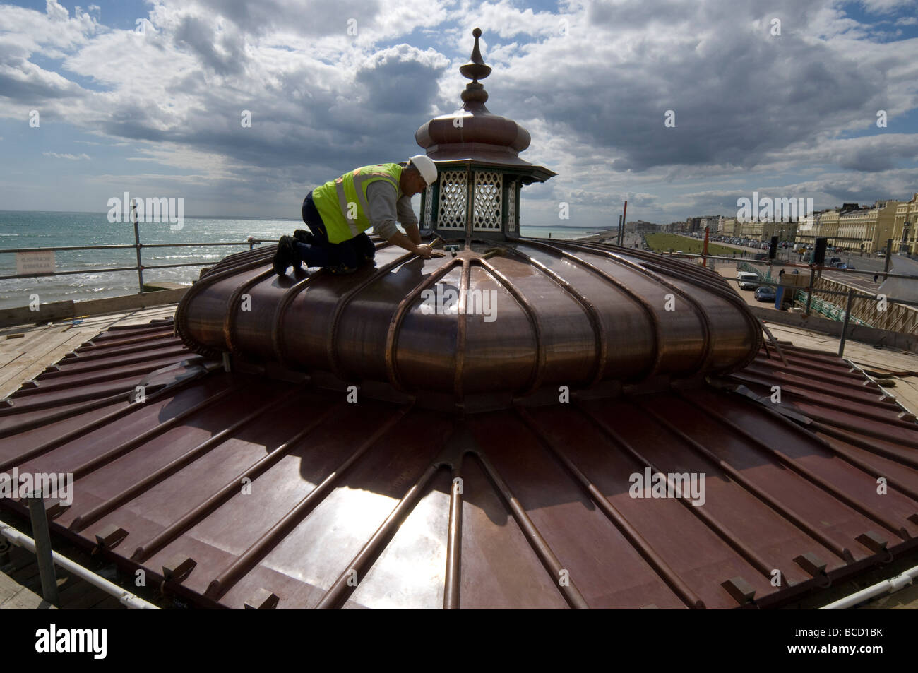 Ein Arbeiter hämmern ein neues Kupferdach auf einen viktorianischen Musikpavillon auf Brighton und Hove direkt am Meer Stockfoto