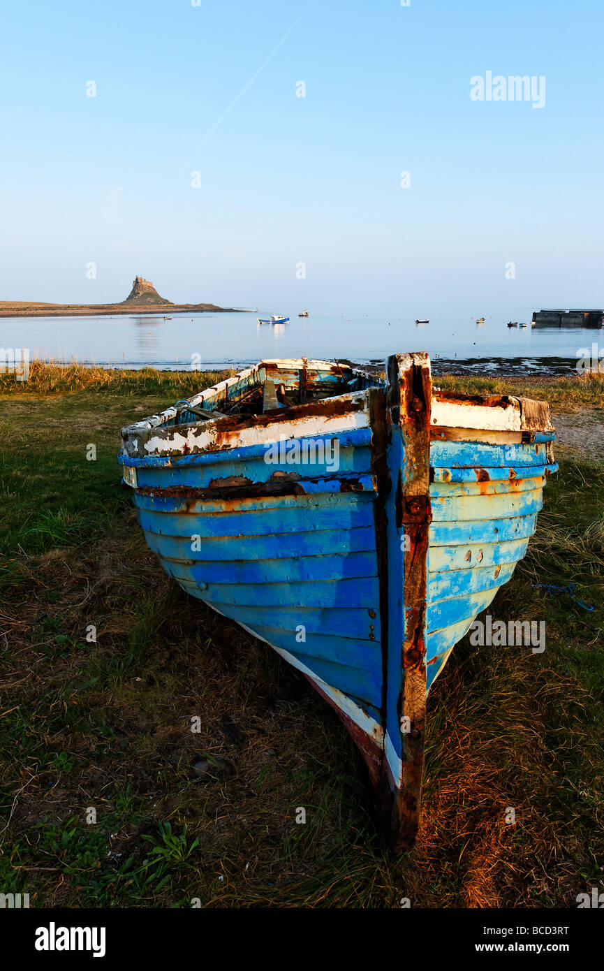 Angelboot/Fischerboot nach oben an der Küste der Heiligen Insel gezogen. Lindisfarne Schloß ist sichtbar über die Bucht. Stockfoto