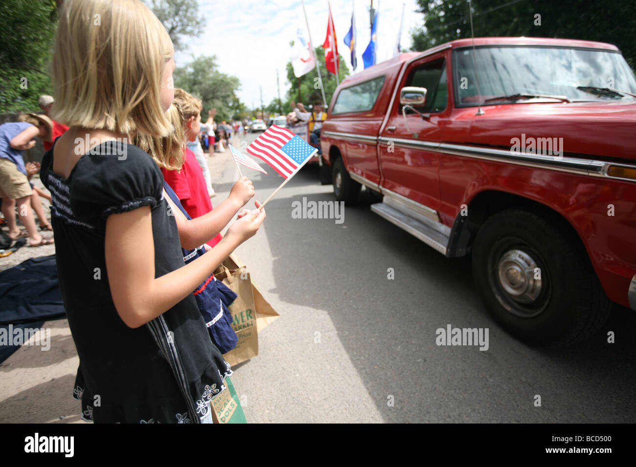 Kinder halten uns Flagge am 4. Juli Parade Stockfoto