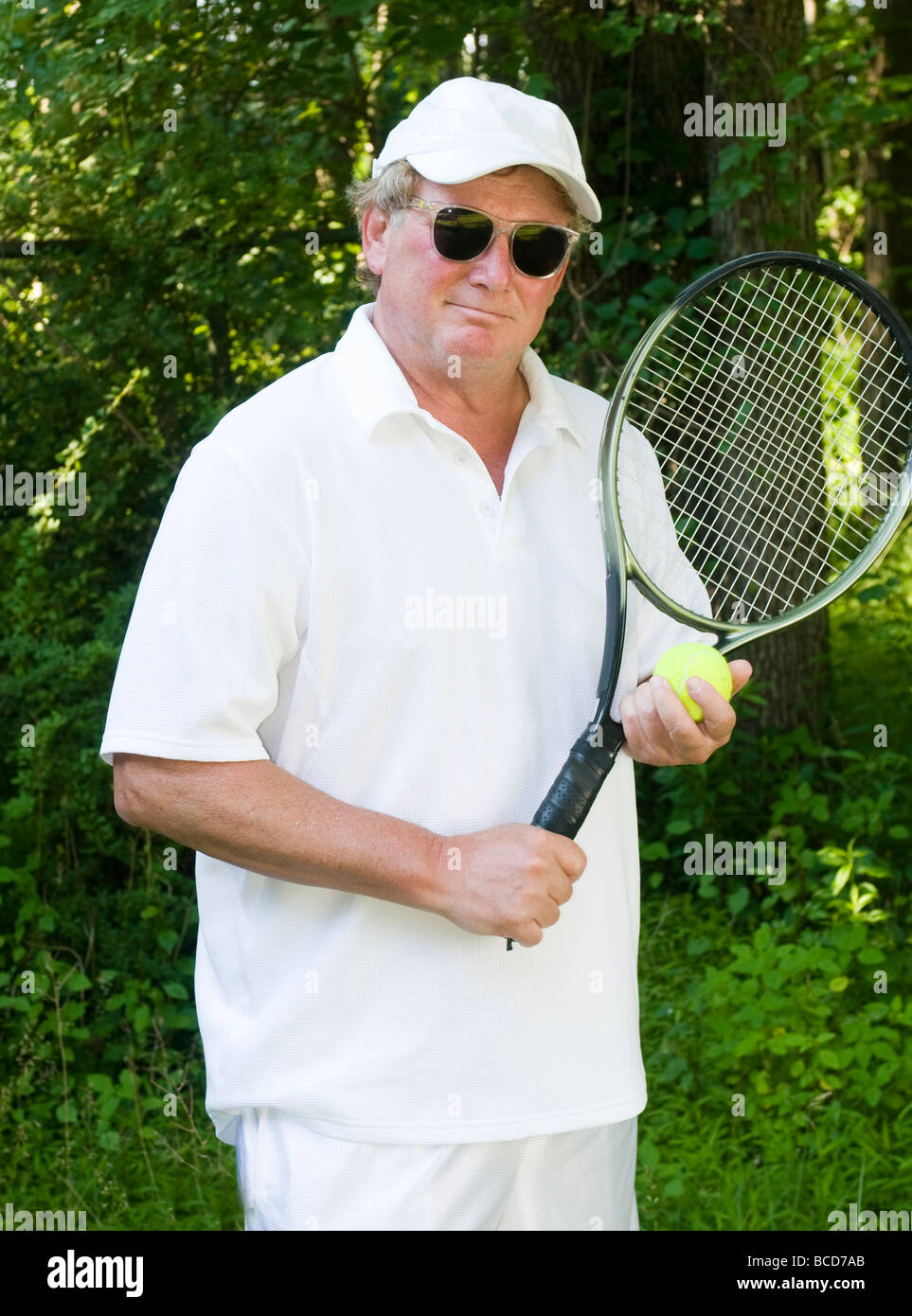 Mann mittleren Alters im Alter Senior Schläger Ball Sport Fitness Übung Gesundheit Ausdruck Gesichts Spieler Tennisbekleidung weißen Polo spielen sh Stockfoto