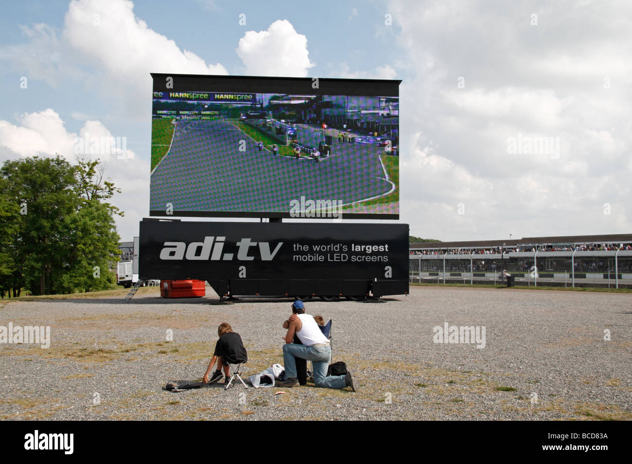 Ein Vater und seine Kinder zuschauen großen Bildschirm an der Superbike-WM Donington Park, Derbyshire, England Stockfoto
