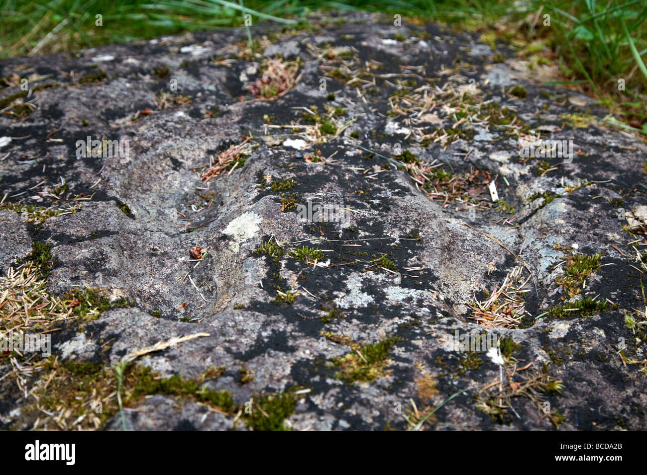 Gortnamoyagh Einweihung Stein dieses Basalt Felsen enthält zwei geschnitzte Fußabdrücke und kleinen kreisförmigen Vertiefungen bilden eine kreuzförmige Stockfoto