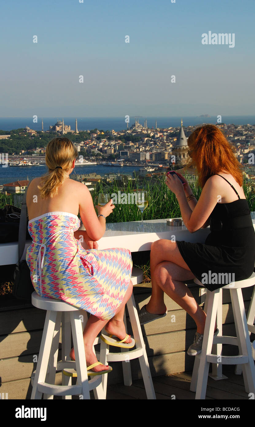 ISTANBUL, TÜRKEI. Zwei junge Frauen trinken und Blick über die Stadt aus einer Bar auf der Dachterrasse im Stadtteil Beyoglu. 2009. Stockfoto