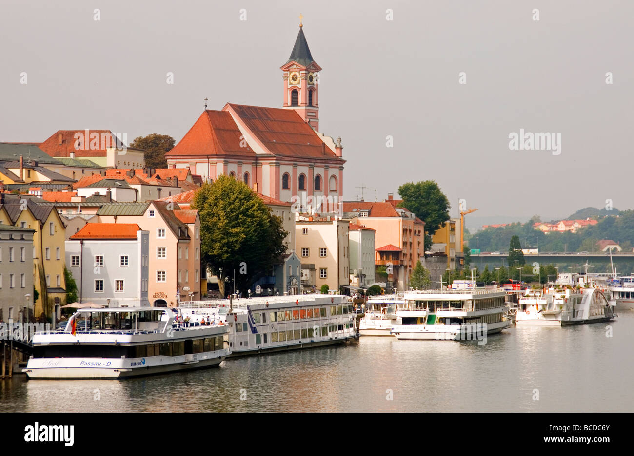 Danube (Donau)-Fluss-Kreuzfahrtschiffe in Passau mit St. Paul Church oben Stockfoto