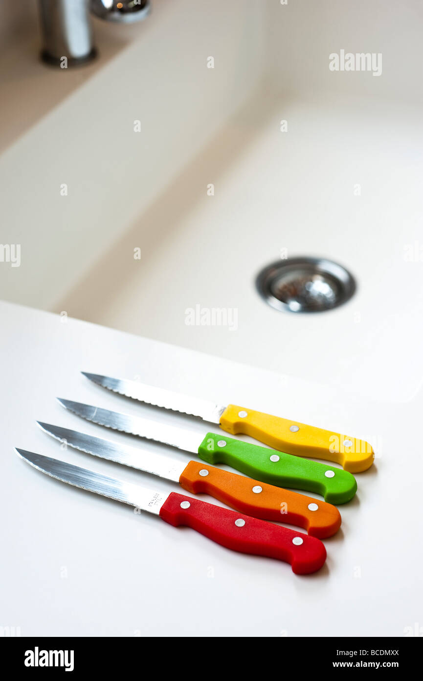 Ausschnitt des bunten Steakmesser auf weißem Hintergrund der Küchenspüle im Hintergrund Stockfoto