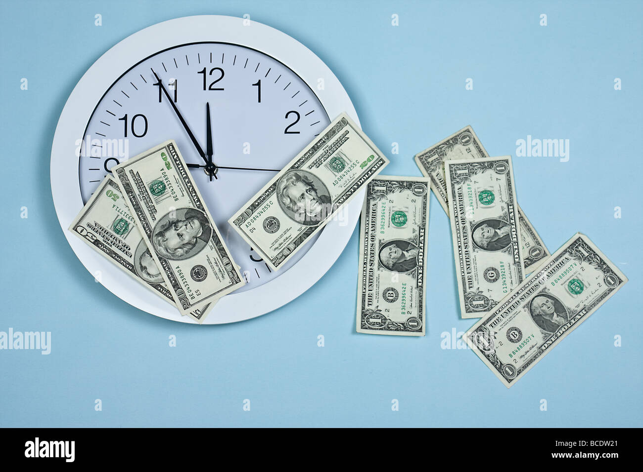 Uhr und Geld auf blauem Hintergrund Stockfoto