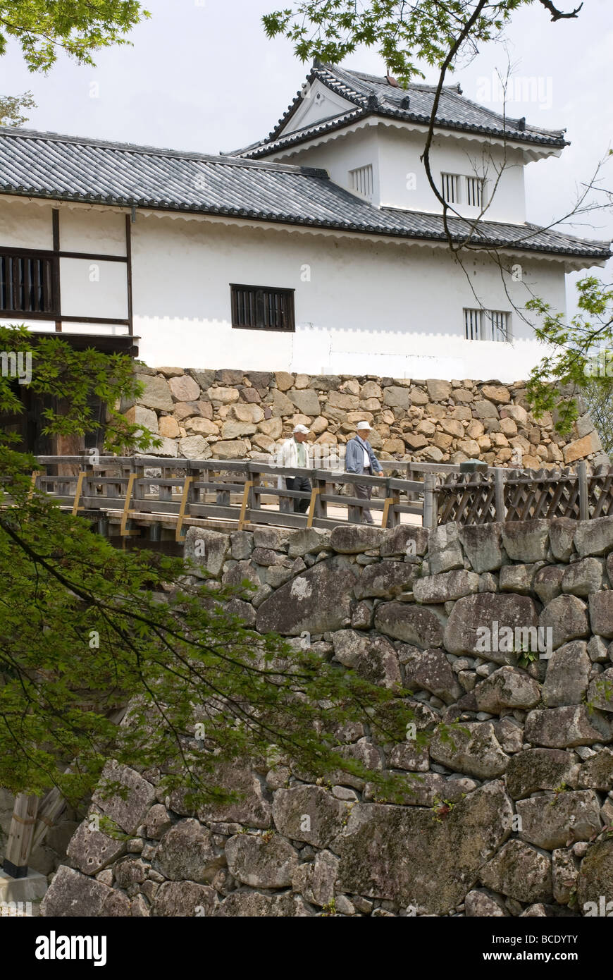 Zwei ältere Männer, die über eine Brücke überqueren, beim Verlassen der Burg Hikone in der Präfektur Shiga, einer der Nationalschätze Japans Stockfoto