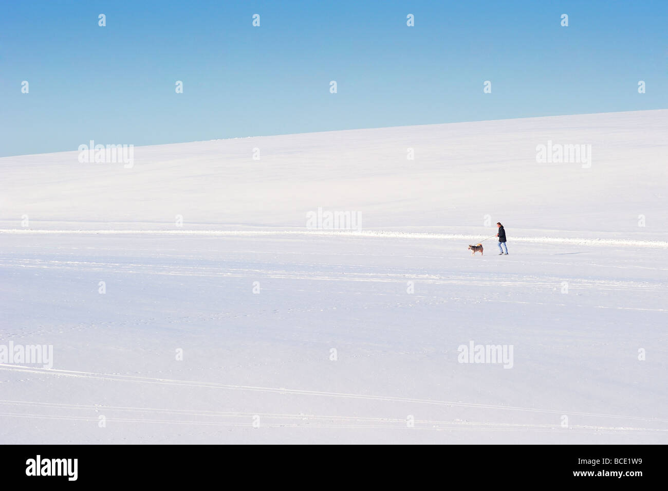 Einsame Figur in einer verschneiten Landschaft Stockfoto