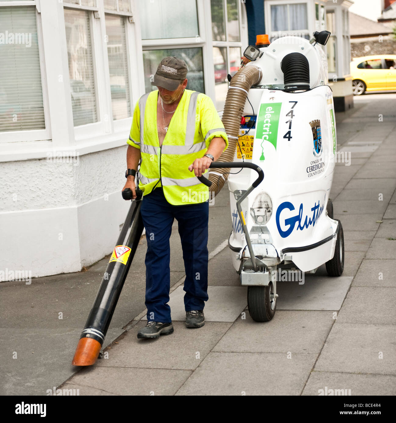 Kommunale Arbeitnehmer Reinigung der Straßen mit einer elektrischen angetrieben industriellen Maßstab Vielfraß Staubsauger UK Stockfoto