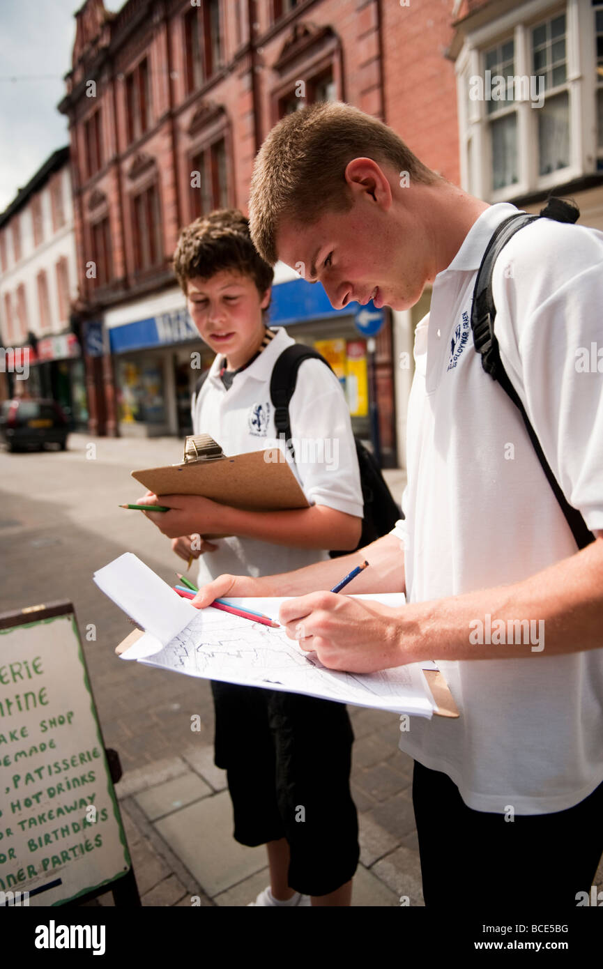 Zwei GCSE-Schüler auf einem Feldkurs Stadtgeographie in einem Stadt-Land verwenden Zuordnung Erfassung der Arten von Geschäften auf Straße Stockfoto