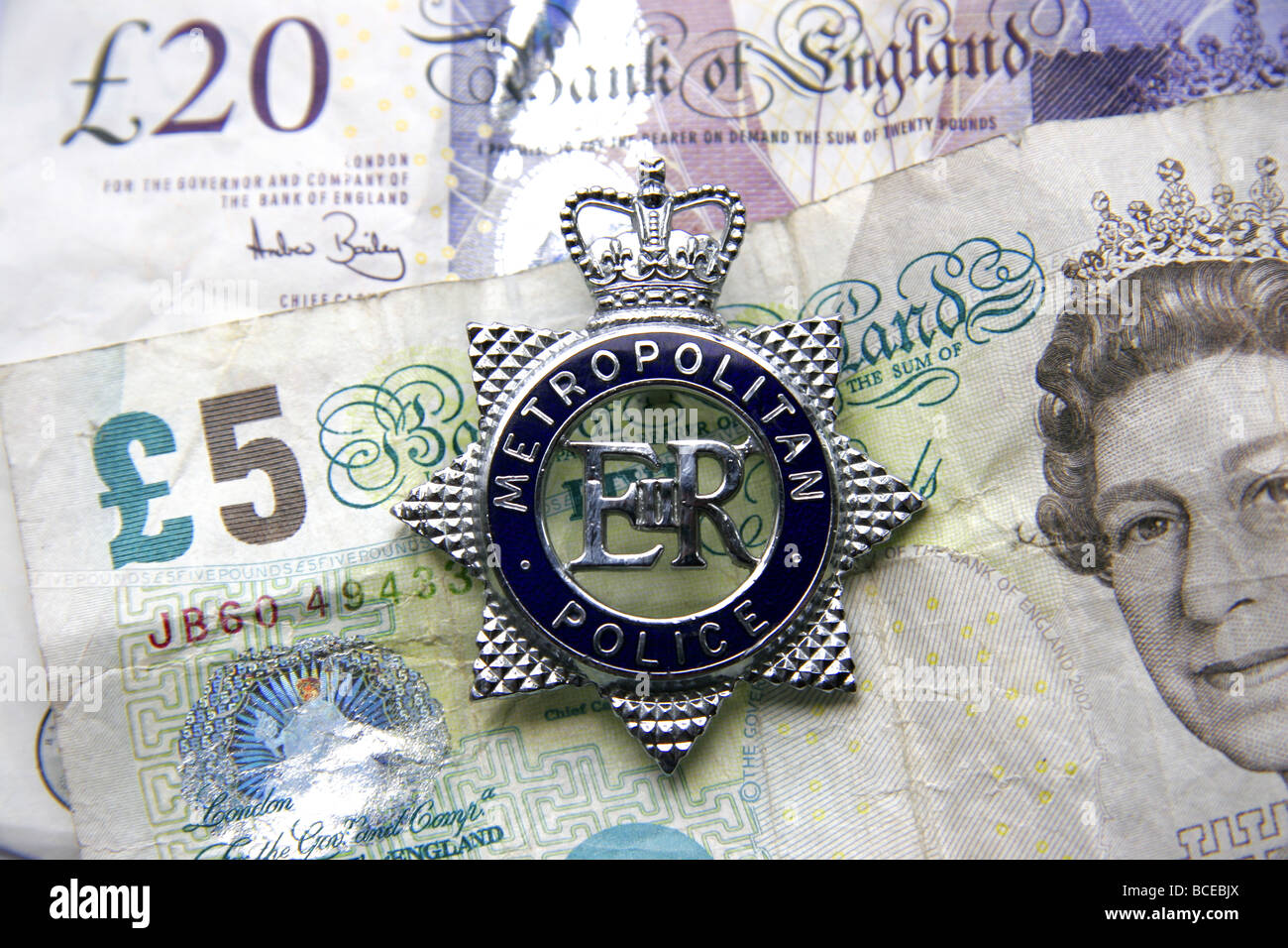 London Metropolitan Police Abzeichen und britisches Geld Stockfoto