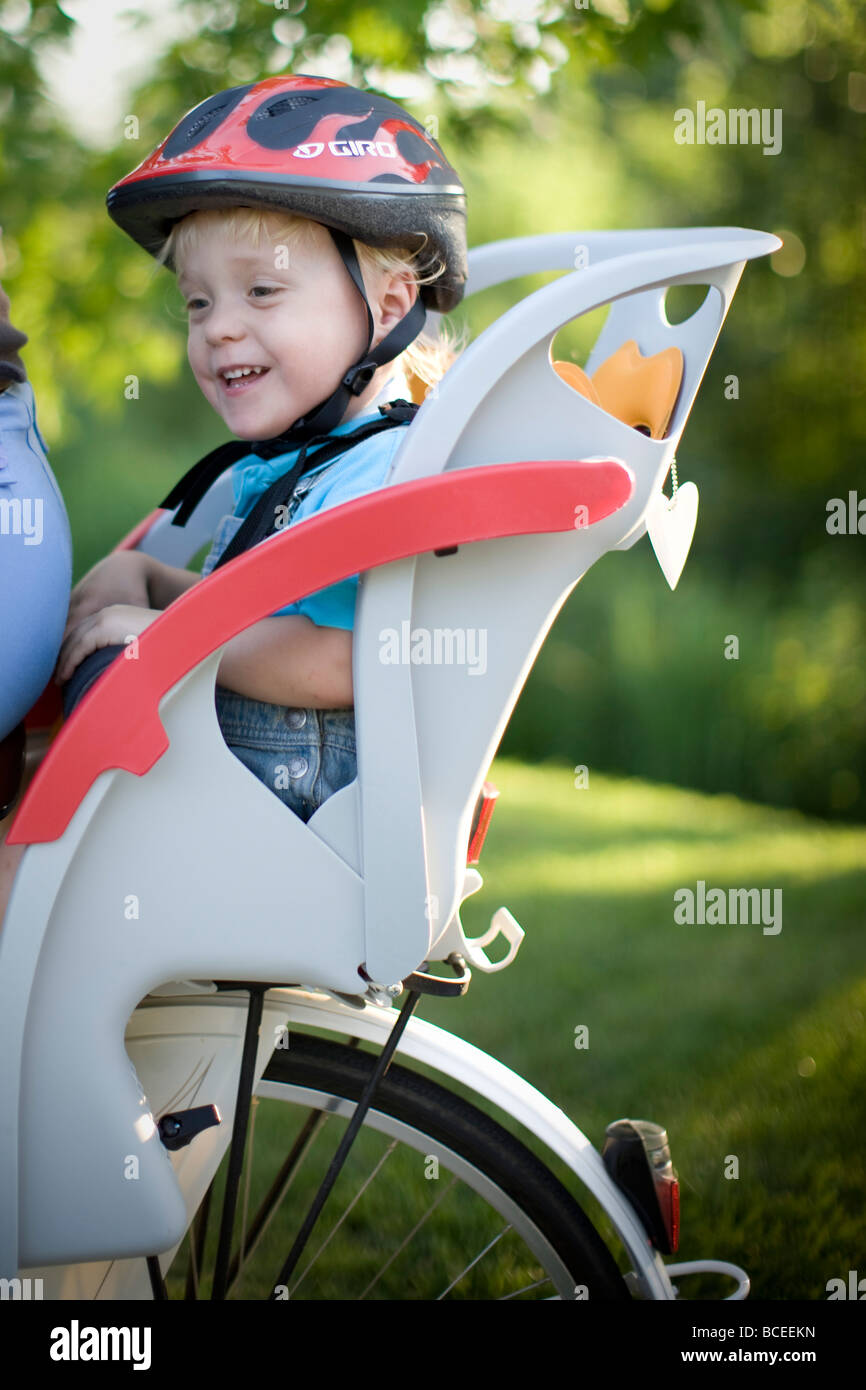 Junge, Reiten in einem Fahrradsitz Stockfoto