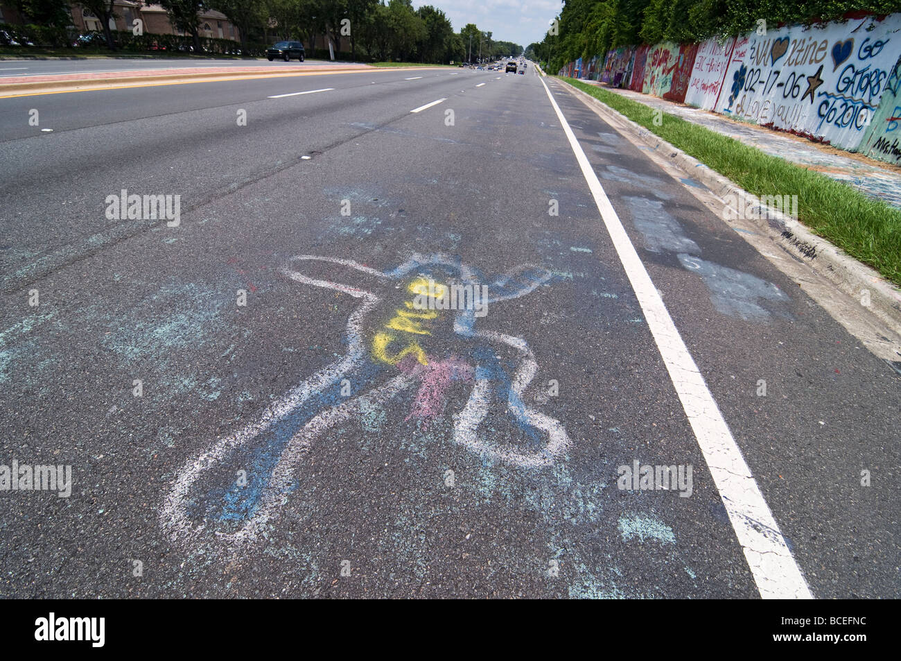 menschliche Opfer Figur bemalt auf Straße neben Graffiti Wall Gainesville Florida Stockfoto