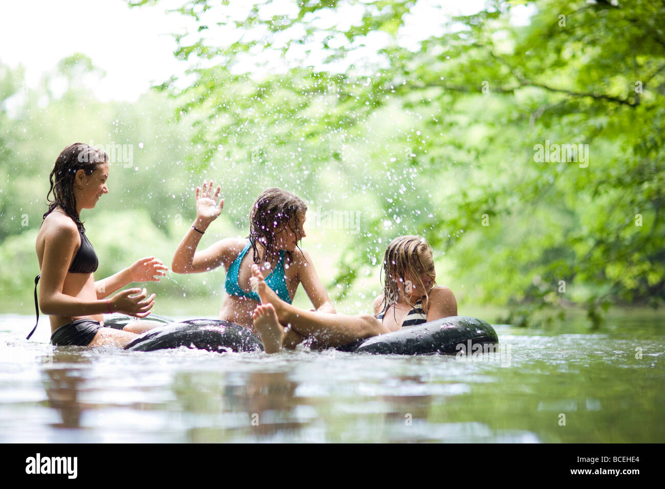 Jugendliche, die Spaß in Innertubes im Wasser Stockfoto