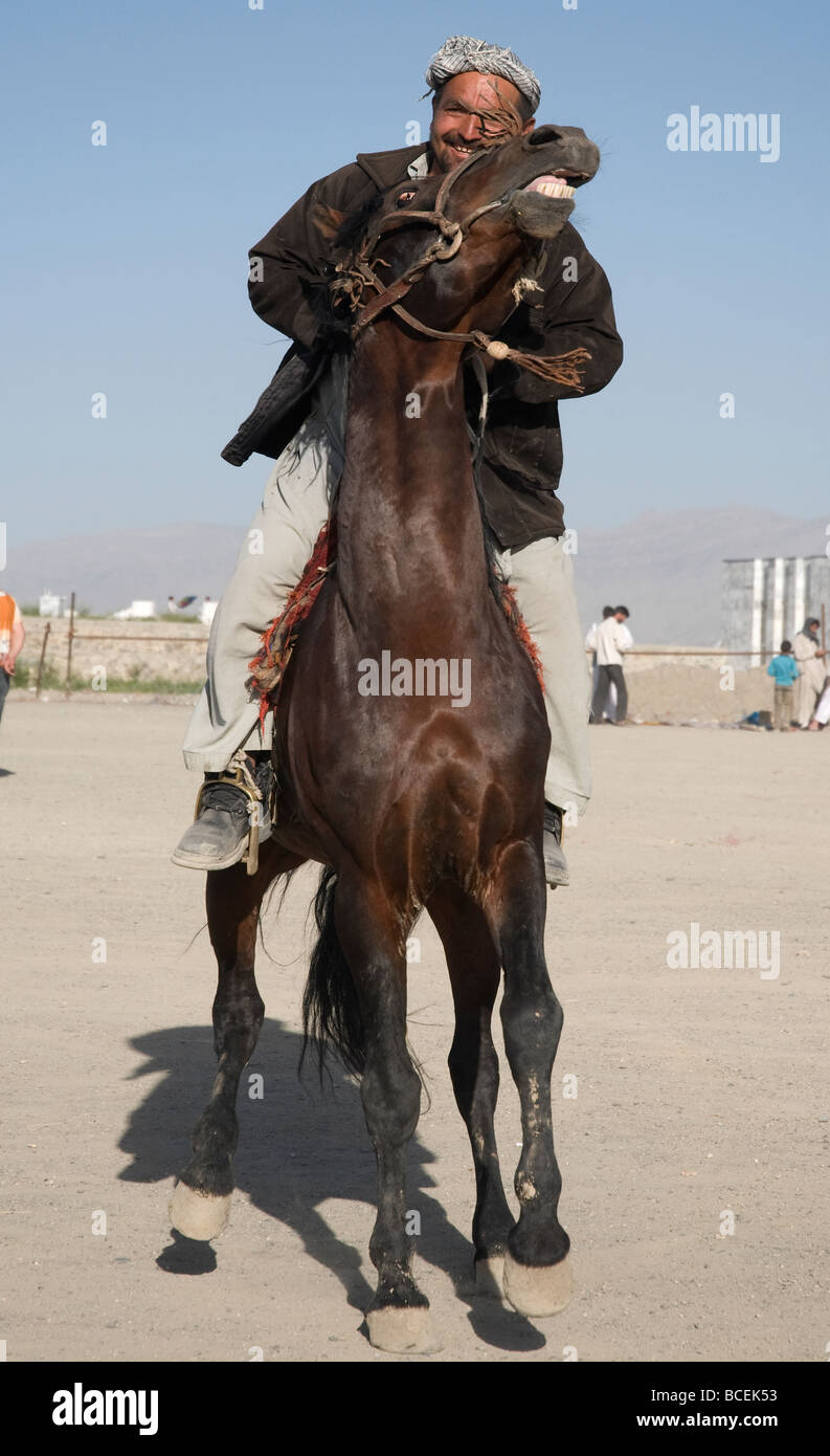 Ein stolzer afghanischen Reiter hemmt seine lebhaften Hengst wie er es auf dem Teppe Maranjan-Plateau in Kabul zeigt Stockfoto