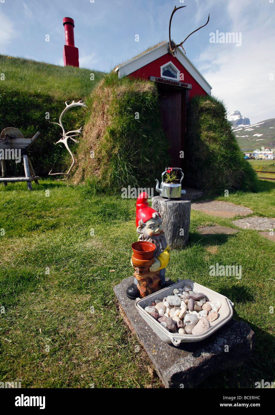 Ein Gartenzwerg vor einem Rasen-Haus im Dorf von Berggipfeln, Island Stockfoto