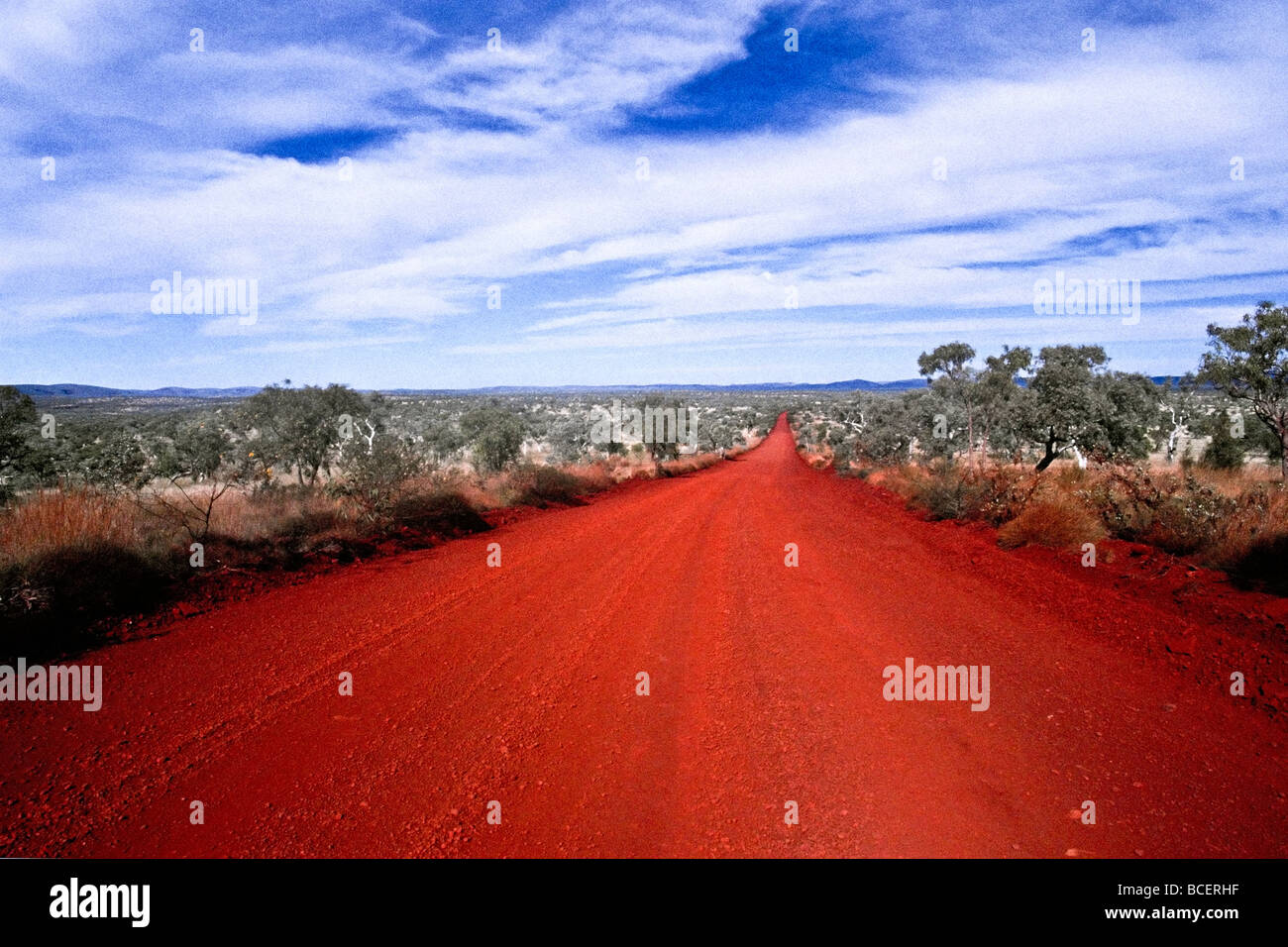 Eine reiche rote vulkanische Strecke verläuft quer durch die Wüstenebene. Stockfoto