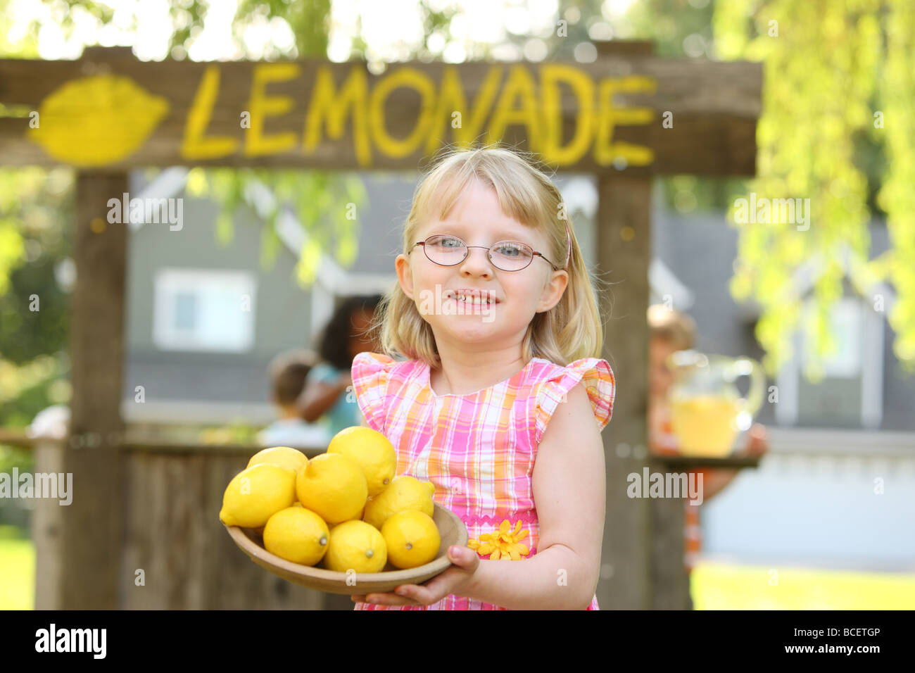 Junges Mädchen vor Limonadenstand mit Zitronen Stockfoto