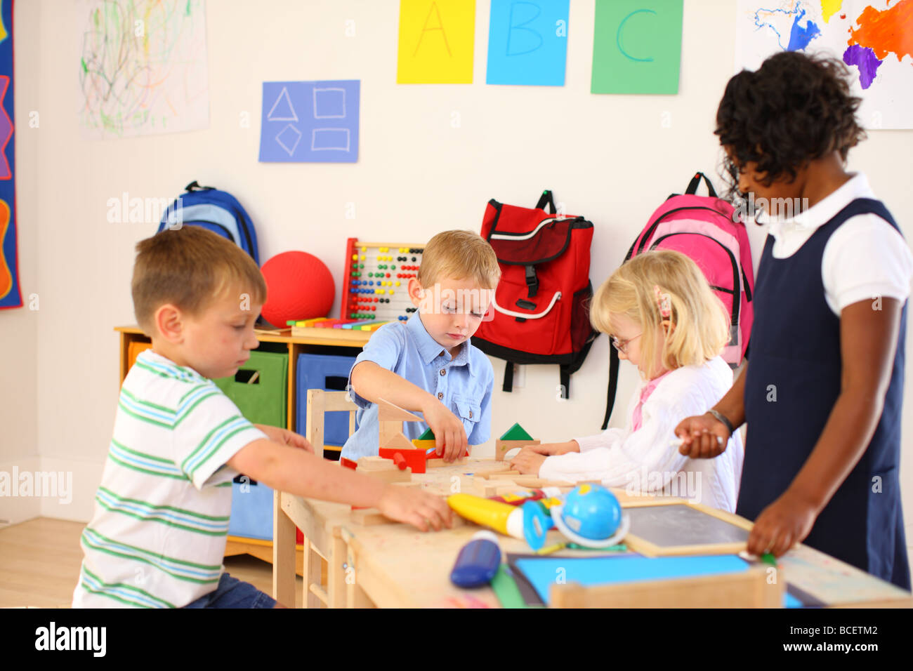 Vier Kinder im Vorschulalter Klassenzimmer spielen Stockfoto