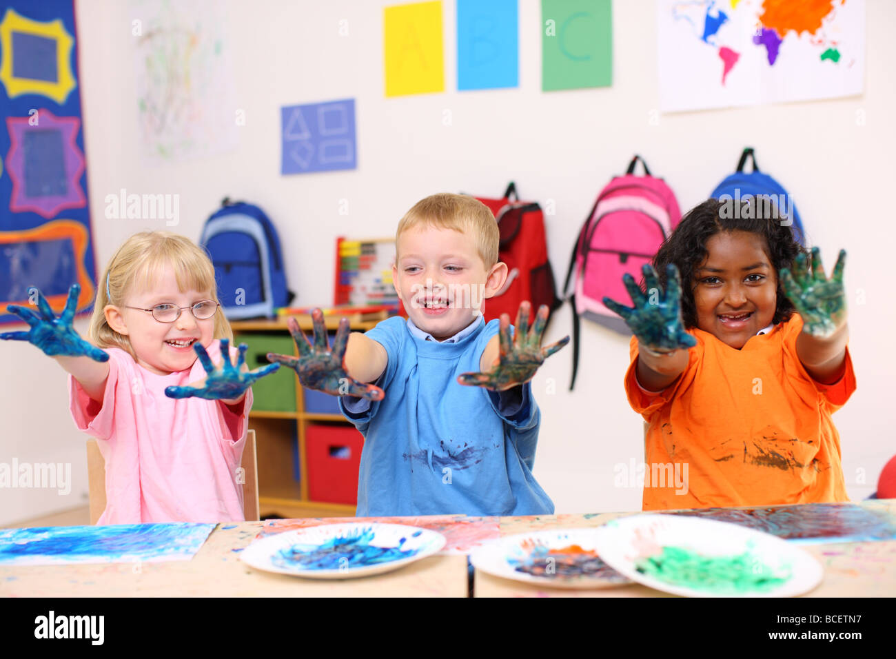 Drei Kinder im Vorschulalter mit Händen bedeckt in Farbe Stockfoto