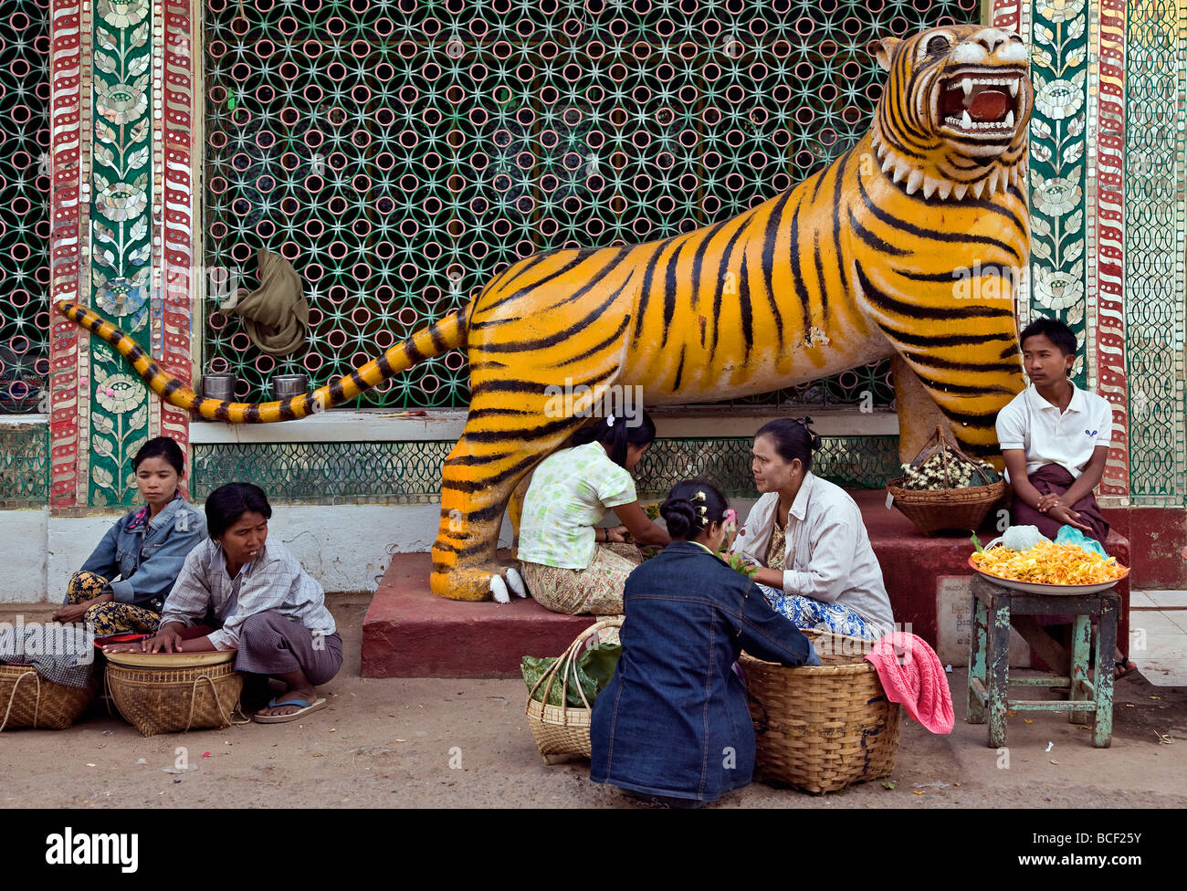 Myanmar. Burma. Popa. Lebensmittel und Blumen Verkäufer neben einer Statue eines Tigers am Fuße des Mount Popa. Stockfoto