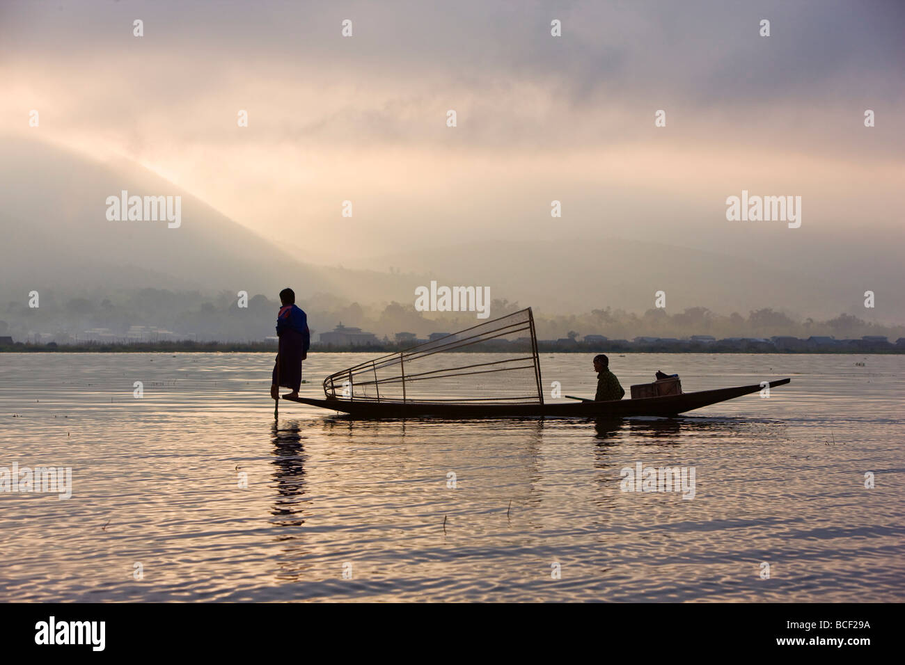 Myanmar, Burma, Lake Inle. Ein Intha Fischer mit traditionellen Fischfalle verwendet eine ungewöhnliche Bein Rudern Technik Stockfoto