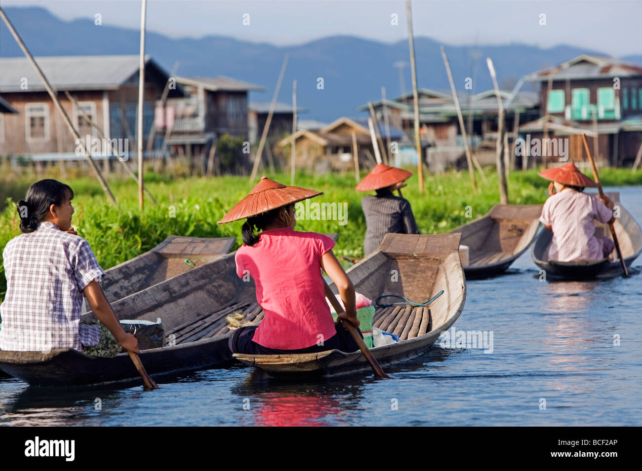 Myanmar, Burma, Lake Inle. Eine Gruppe von Intha Frauen paddeln ihre flachen Holzbooten auf den Markt. Stockfoto