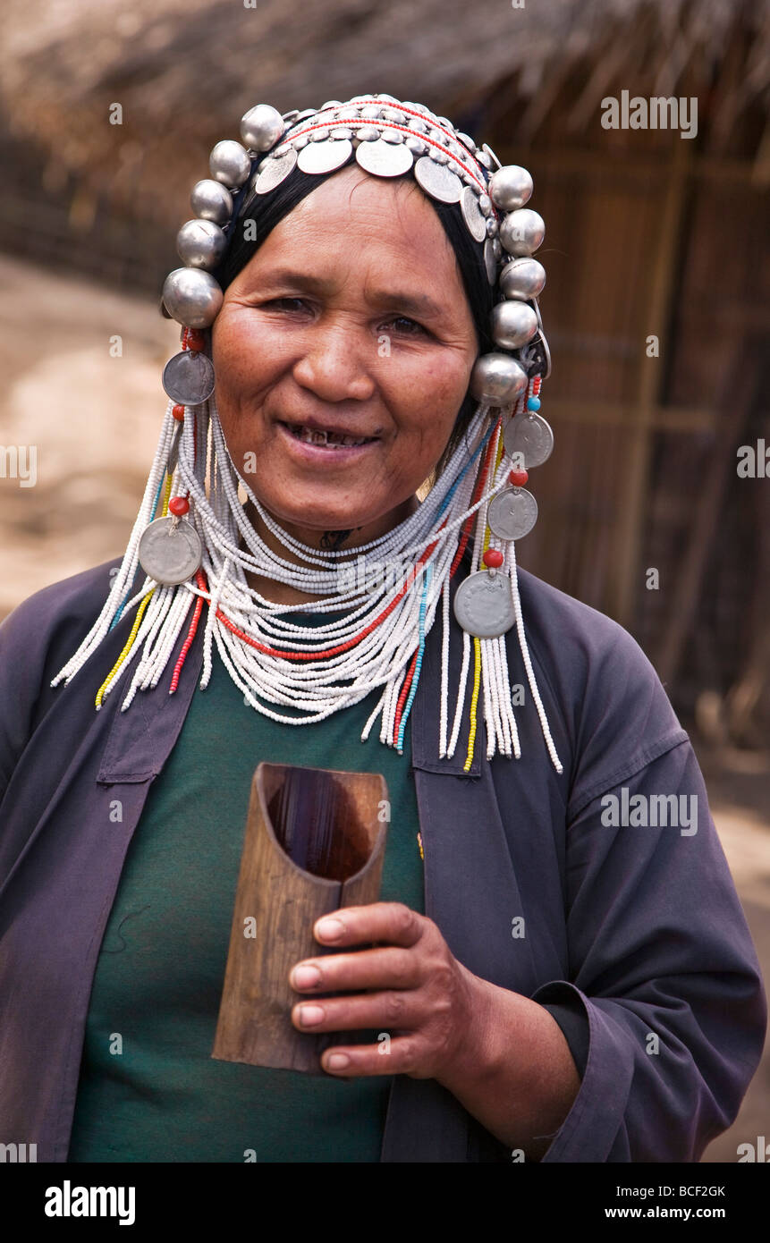 Myanmar, Burma, Namu-Op. Eine Akha Frau tragen Tracht mit einem Kopfschmuck Perlen hält einen Bambus-Becher. Stockfoto
