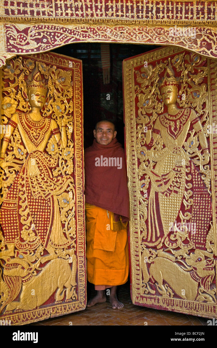 Myanmar, Burma, Wun Nyat. Der Abt schließt die reich verzierten Tür zum schönen Wun Nyat Kloster. Im 15. Jahrhundert erbaut. Stockfoto