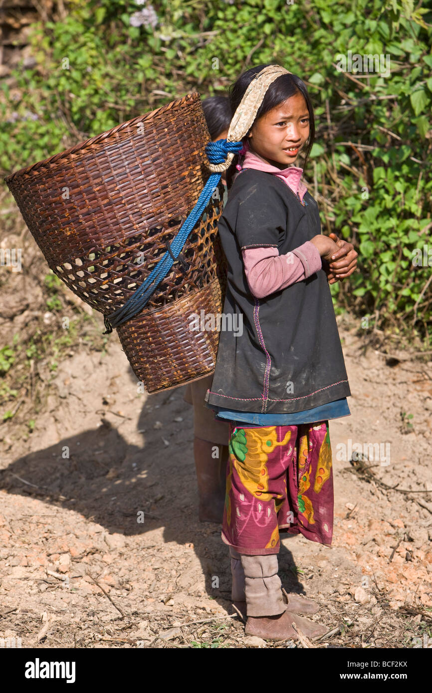 Myanmar, Burma, Wan-seeing.  Ein junges Loi Mädchen tragen einen großen Weidenkorb im Wan-seeing Village. Stockfoto