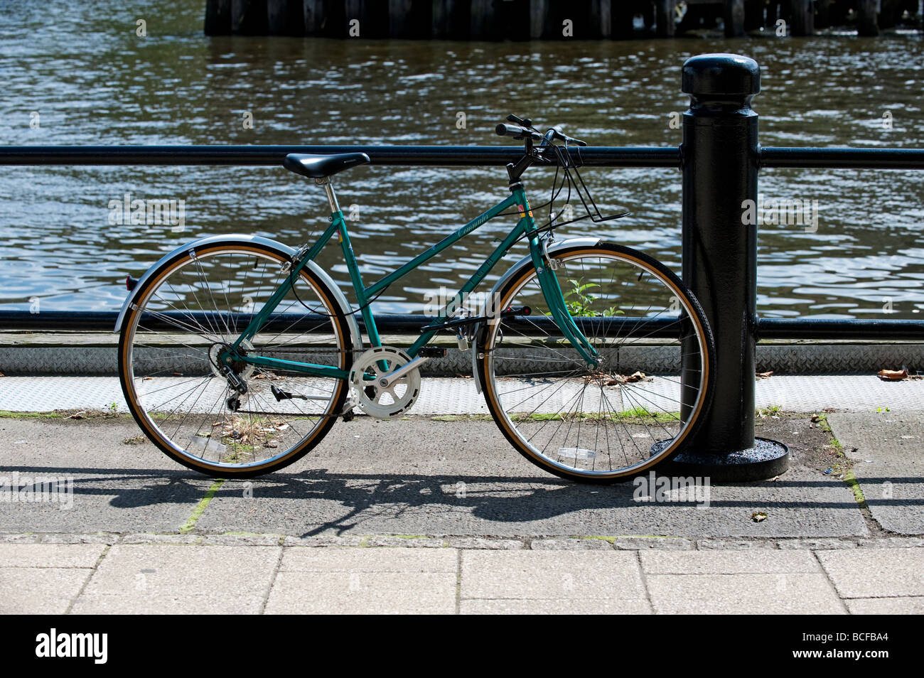 Fahrrad angekettet an Geländer auf Kai, Newcastle-upon-Tyne Stockfoto