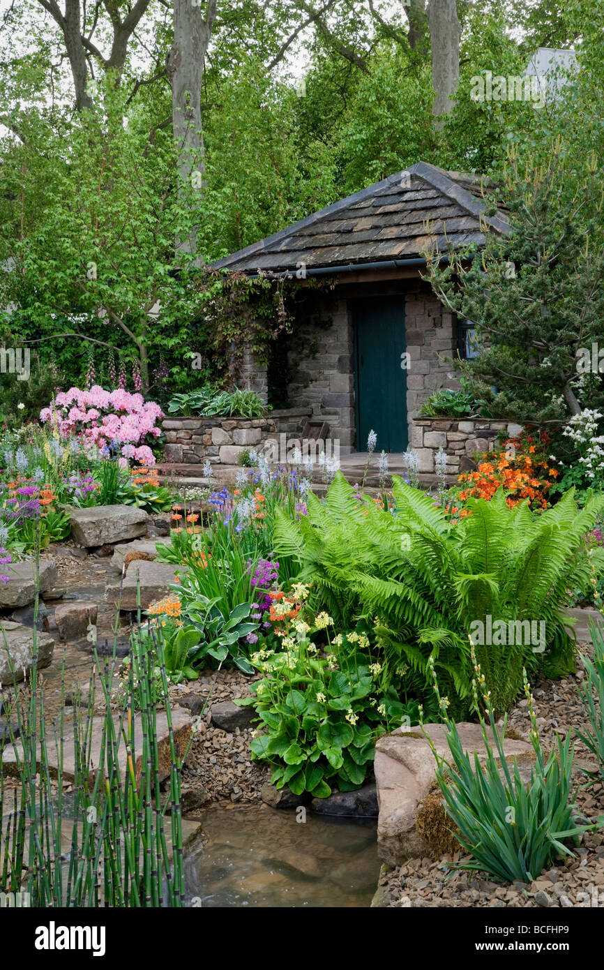 Stein-Ferienhaus in Regen Garten mit Strom für Regenwasser-Sickerschacht und Sumpf-Pflanzen Stockfoto