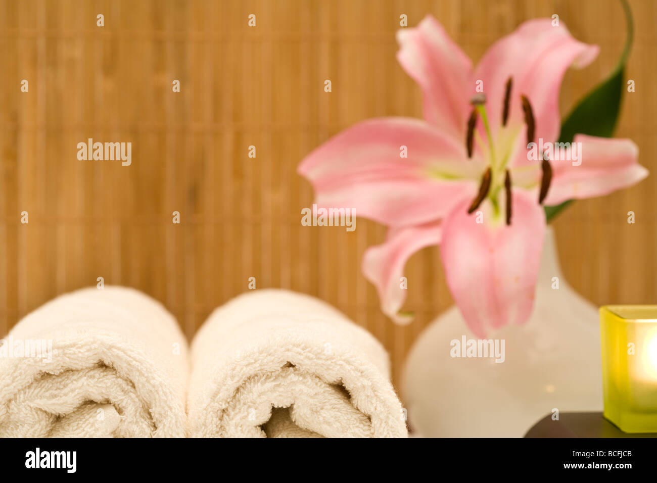 Spa und Wellness Hintergrund mit gerollte Handtücher, Lilie, Kerze, Bambusmatte Stockfoto