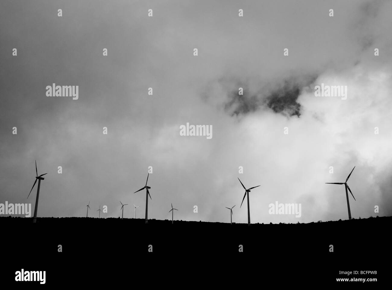 Schwarz / weiß Silhouette von Windenergieanlagen auf Hügel. Stockfoto