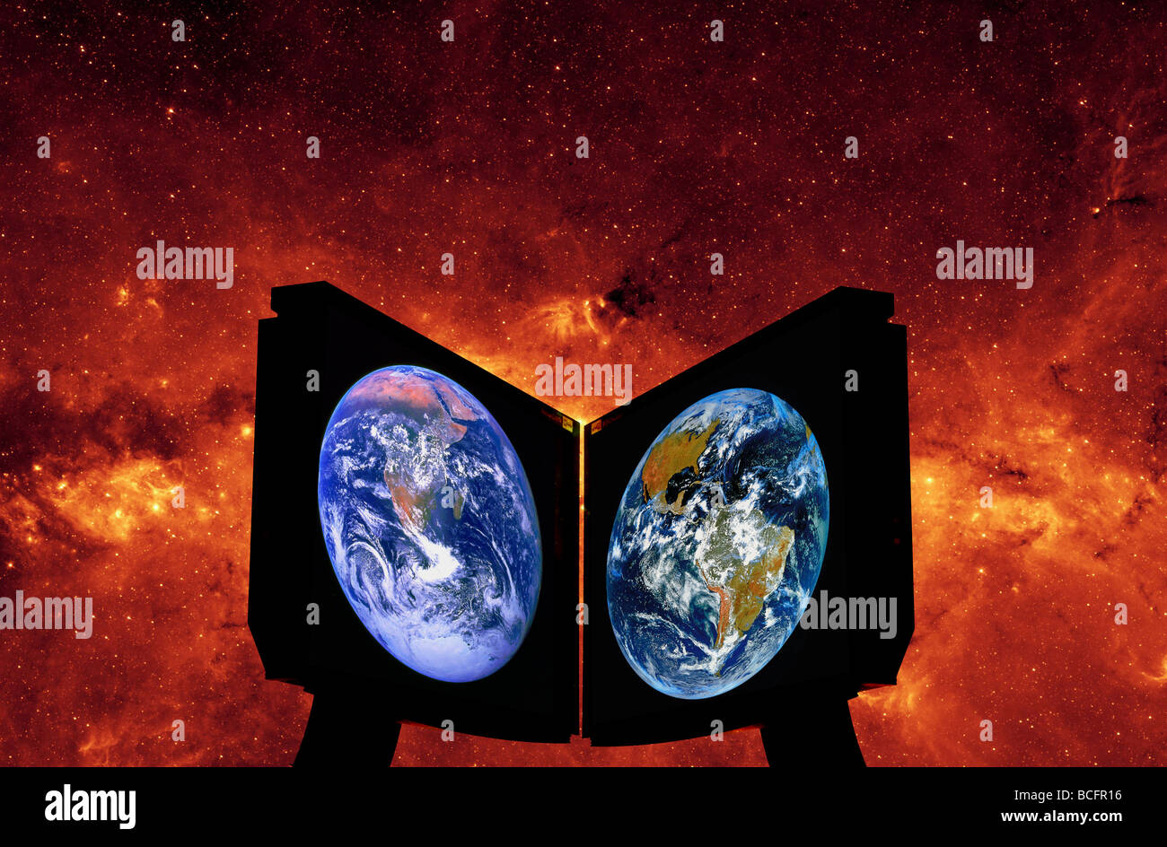 Dual Computermonitore mit NASA-Satellitenbilder der Erde vor einem Hintergrundbild der Milchstraße Stockfoto