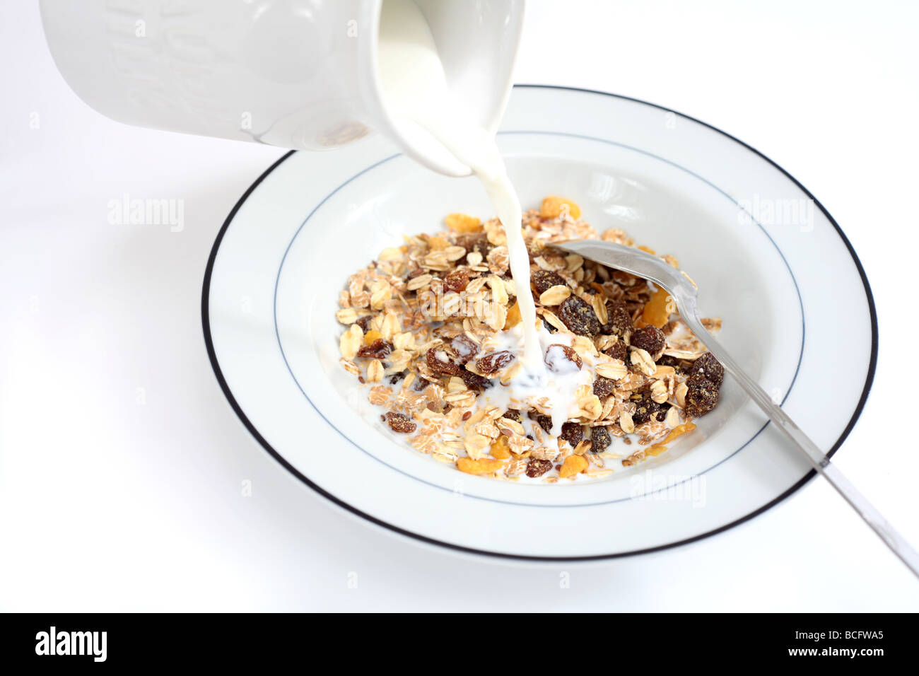 Ein gesundes Frühstück aus Müsli mit Milch darauf gegossen wird Stockfoto
