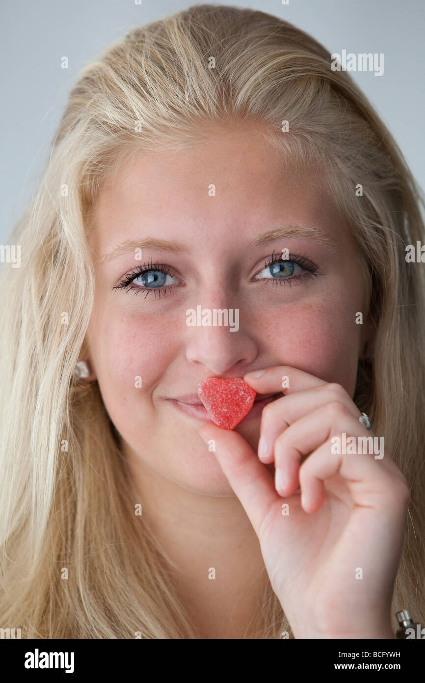 Porträt eines Mädchens mit einem herzförmigen Bonbons Stockfoto