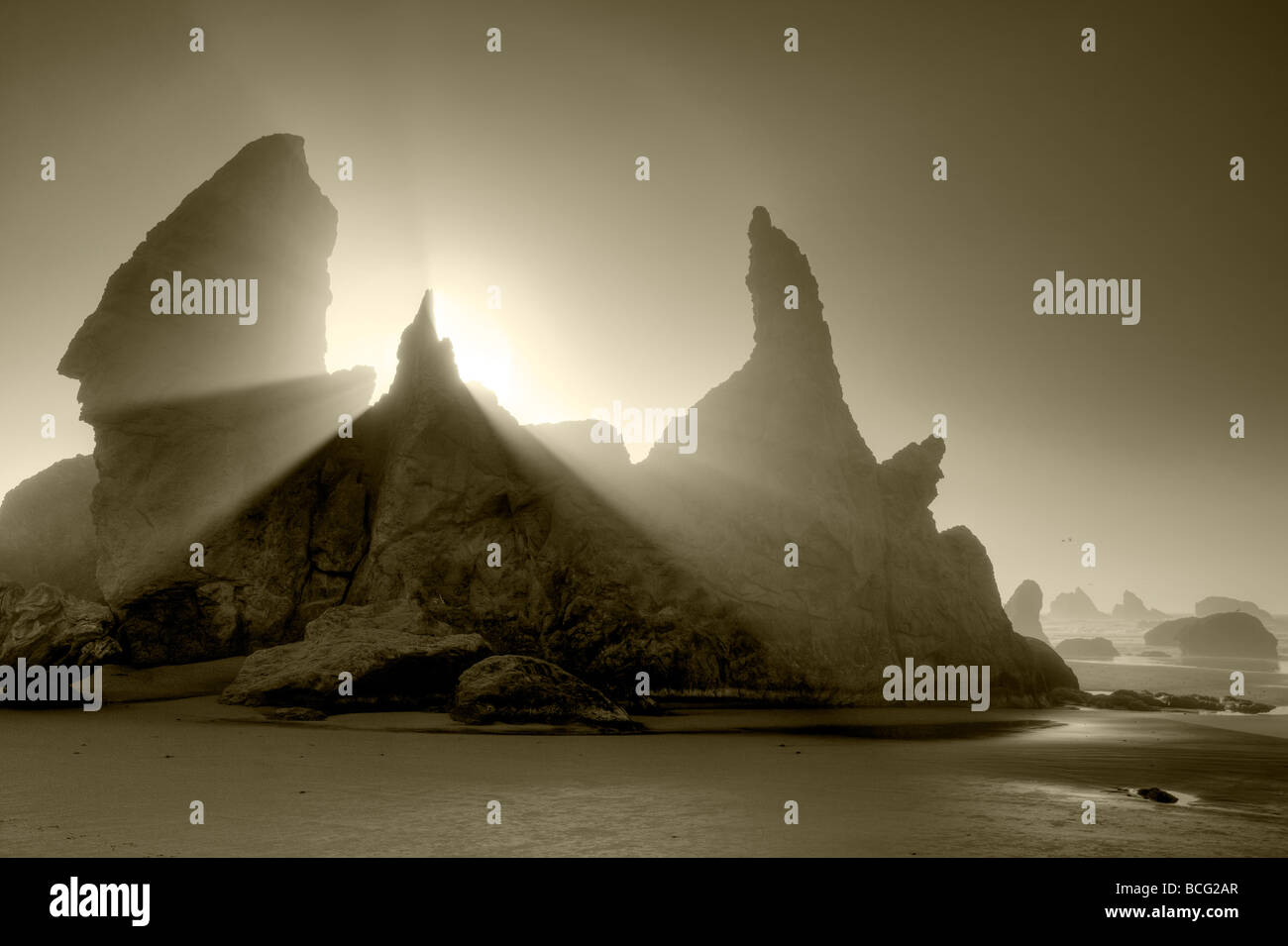 Meer-Stacks in Bandon Beach mit Nebel und Sonne Strahlen Oregon Stockfoto