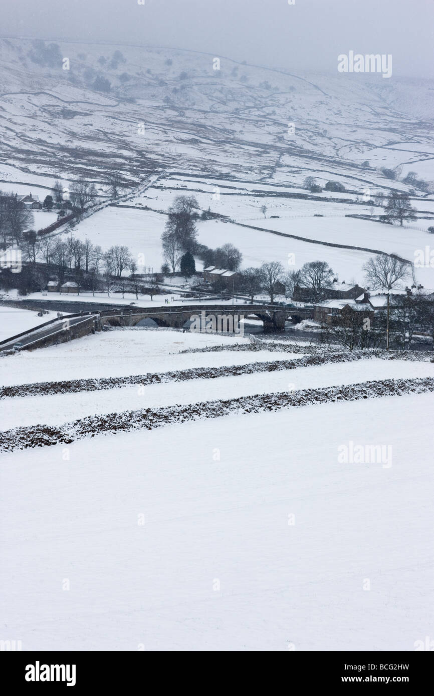 Mit Blick auf die Brücke im Dorf Burnsall, Yorkshire Dales an einem verschneiten Tag im winter Stockfoto