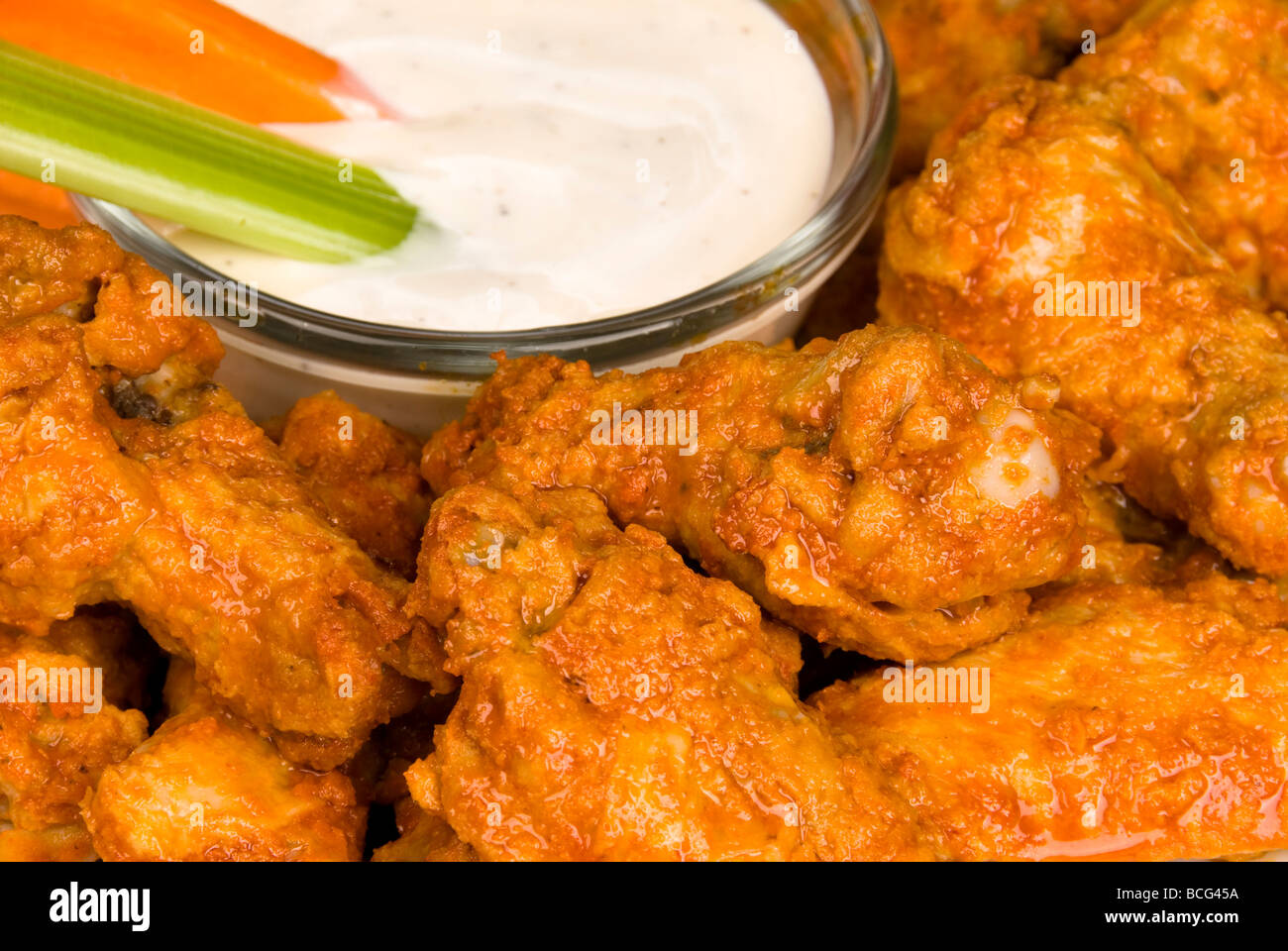 Eine Nahaufnahme von knusprig würzige Hähnchenflügel auch bekannt als hot Wings mit Ranch DIP-Sauce Stockfoto