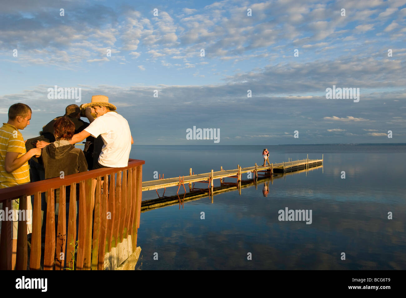 Junge Menschen entspannen durch hölzerne Pier mit Blick auf Puck Bucht Hel Halbinsel Ostsee Polen Stockfoto