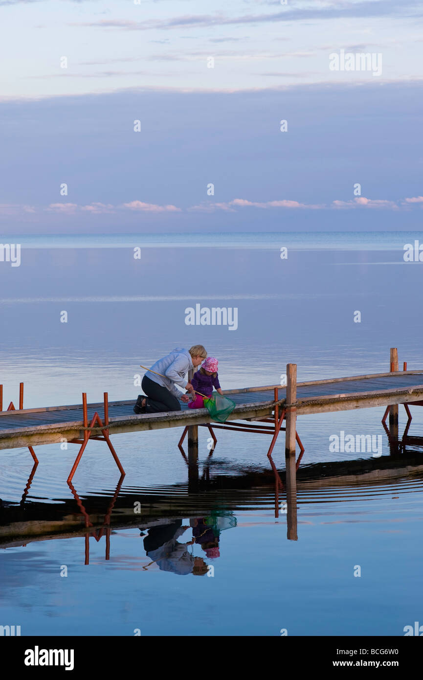 Mutter und Tochter auf Holzsteg mit Blick auf Bucht von Puck am frühen Abend Hel Halbinsel Ostsee Polen Stockfoto