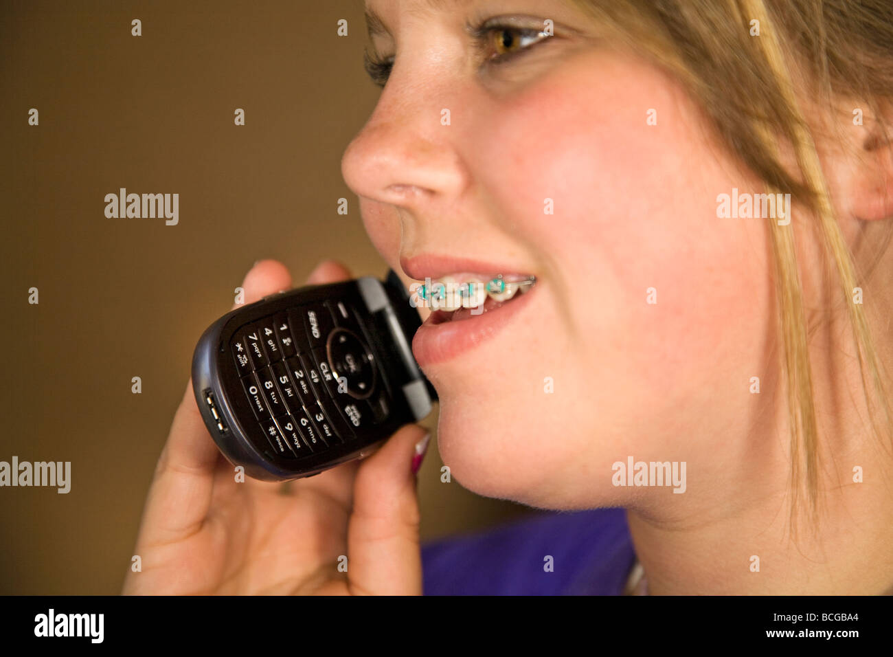 Ein Teenager mit geschweiften Klammern am Handy oder ein Flip-Telefon sprechen. Stockfoto